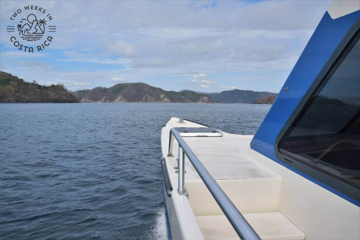 Side view of catamaran showing part of the hull cutting through the water