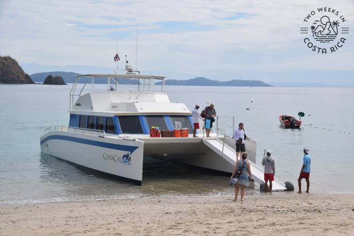 catamaran boat pulled onto the sand with ramp extended