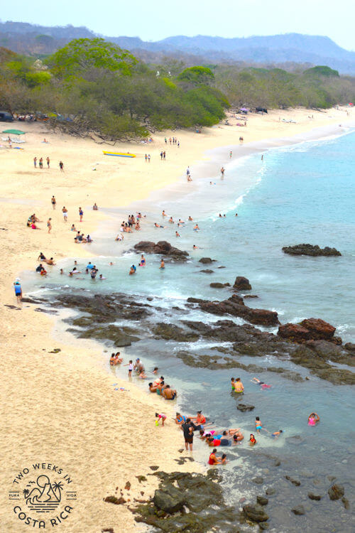 white sand beach with turquoise water and rocks