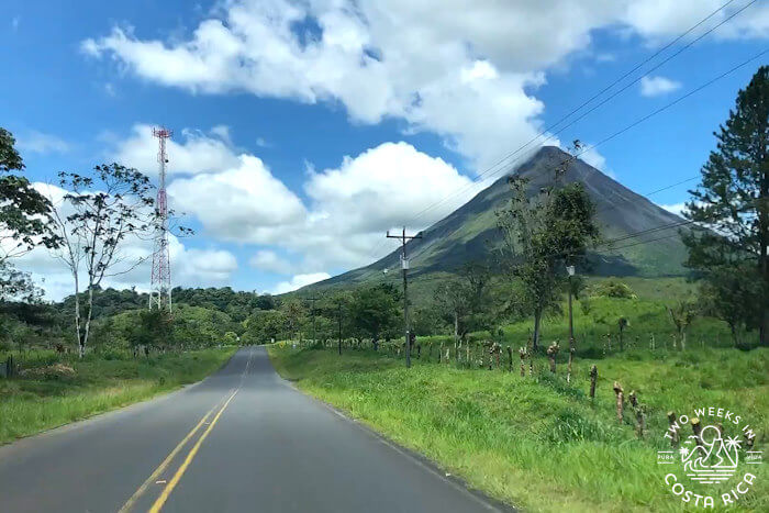 Paved road in Costa Rica with Arenal Volcano in the distance