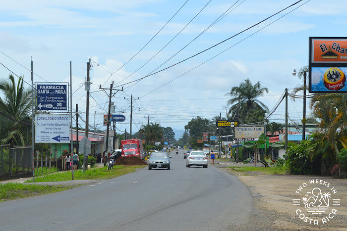 paved road with cars and businesses in Costa Rica